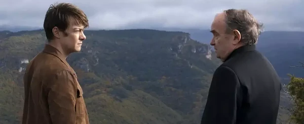 Two men stare at each other against a mountainous backdrop in "Miséricorde"