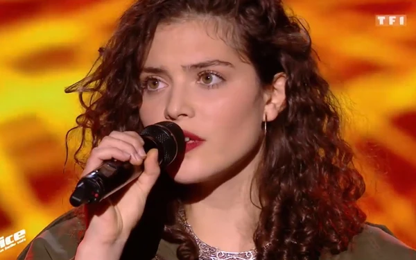 A female contestant performs with a microphone in "The Voice: La Plus Belle Voix".