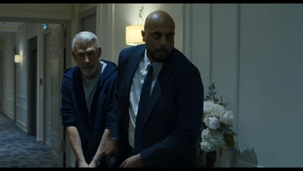 Two men move cautiously in a hallway in Ad Vitam.