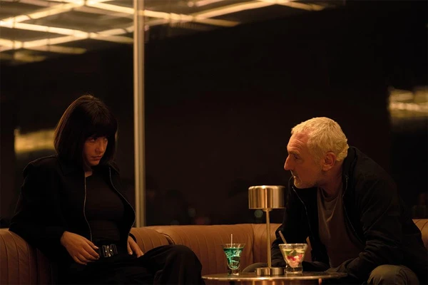 Cop Zem and agent Salia have a tense conversation in an alley in Chien 51.