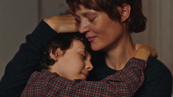 A woman hugs a boy affectionately in Love Me Tender.